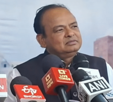 रांची में मीडिया को संबोधित करते हुए झारखंड के स्वास्थ्य मंत्री डॉ. इरफान अंसारी, हाथ में माइक और आक्रामक मुद्रा।