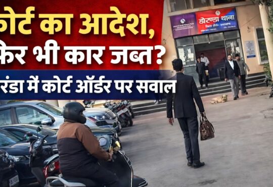 डोरंडा थाना परिसर का दृश्य, सामने पुलिसकर्मी और अधिवक्ता खड़े हैं, पृष्ठभूमि में थाना भवन दिखाई दे रहा है। थंबनेल पर लिखा है – "कोर्ट का आदेश, फिर भी कार जब्त? डोरंडा में कोर्ट ऑर्डर पर सवाल"