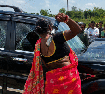 Godda NH-133 road accident protest where an angry woman breaks the Scorpio vehicle's window after the fatal crash in Jharkhand.