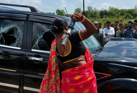 Godda NH-133 road accident protest where an angry woman breaks the Scorpio vehicle's window after the fatal crash in Jharkhand.