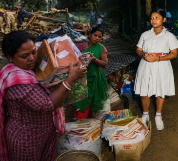 रांची में बुलडोजर कार्रवाई के बाद मलबे के बीच अपनी किताबें संभालती छात्रा लक्ष्मी मुंडा और उसका परिवार।