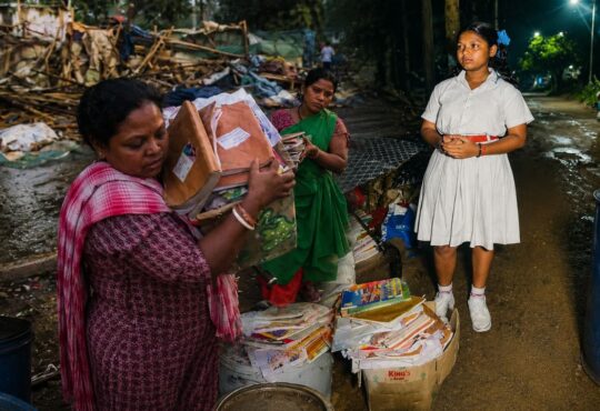 रांची में बुलडोजर कार्रवाई के बाद मलबे के बीच अपनी किताबें संभालती छात्रा लक्ष्मी मुंडा और उसका परिवार।
